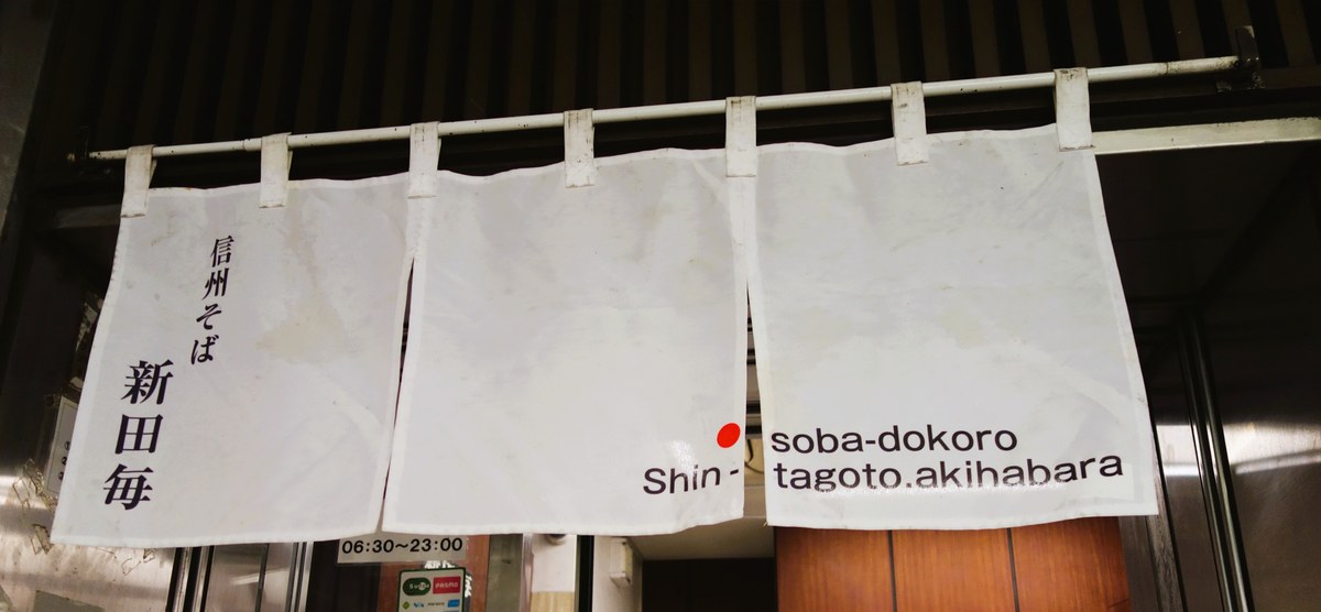 秋葉原駅ホームにある信州そば新田毎の白い暖簾と営業時間06:30〜23:00