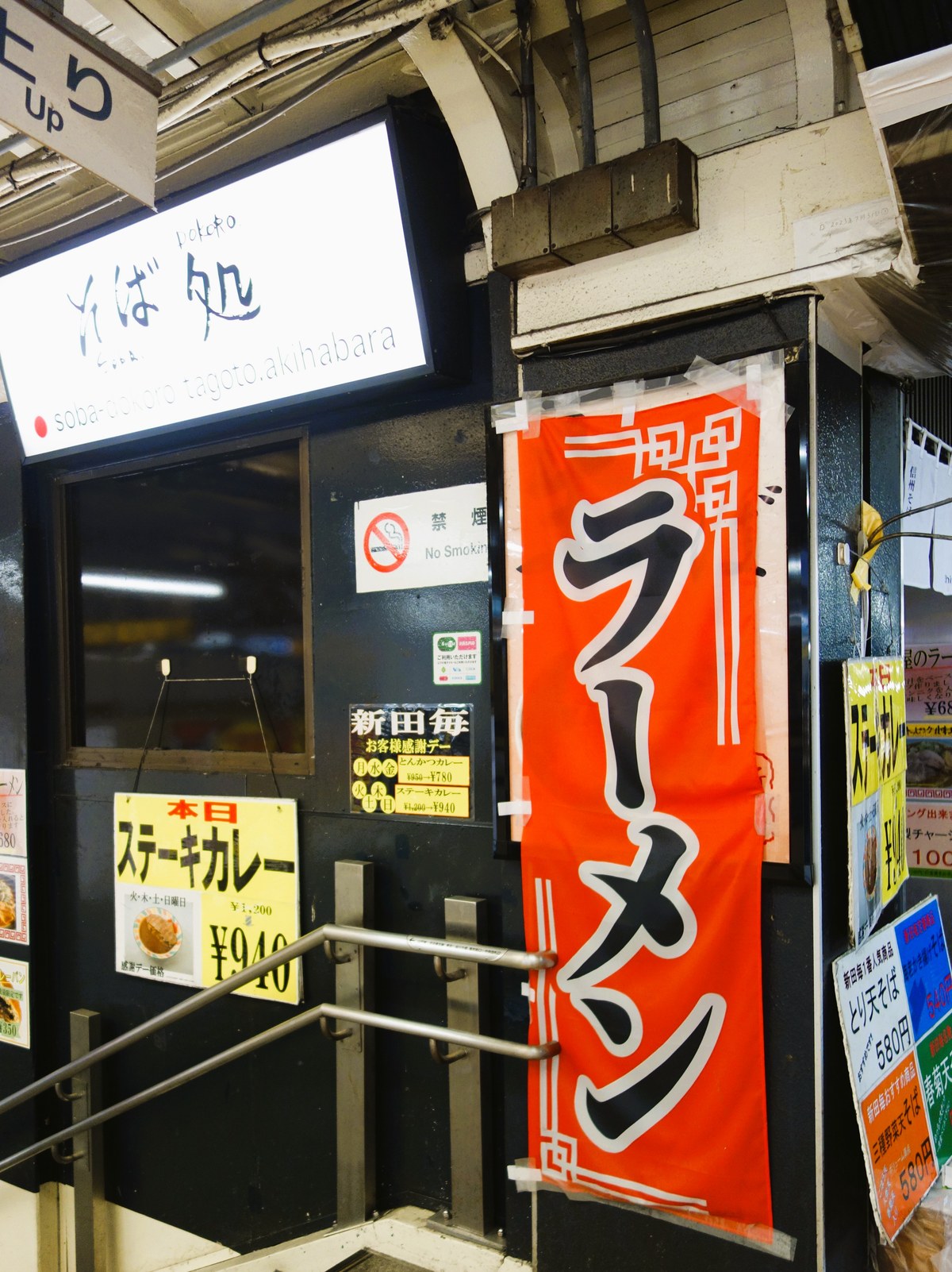 秋葉原駅の階段脇にある新田毎の入口とUp矢印の案内