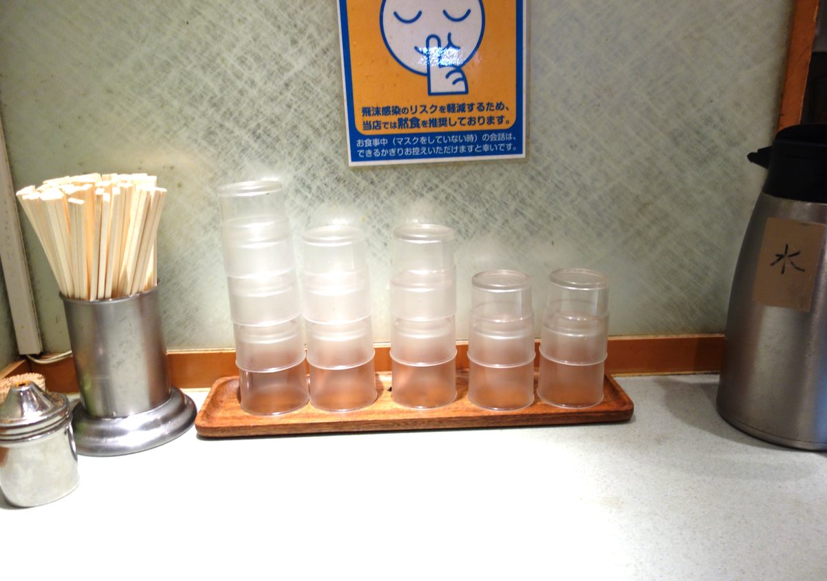 新和そばの店内カウンター — 箸・コップ・水ポットが並ぶ立ち食いスタイル