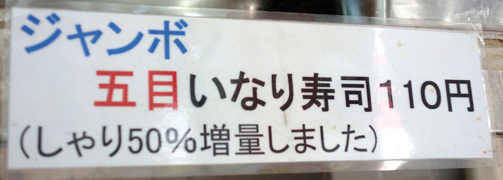 店内の貼紙「ジャンボ五目いなり寿司110円　しゃり50%増量しました」