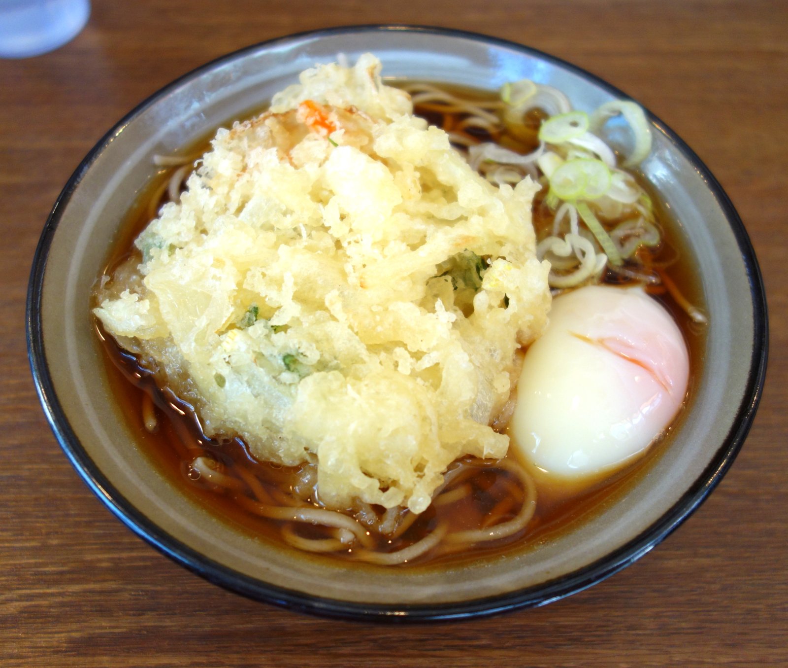 そば処かめやの天玉そば。分厚いかき揚げの脇に半熟の温泉玉子、上にきざみネギ