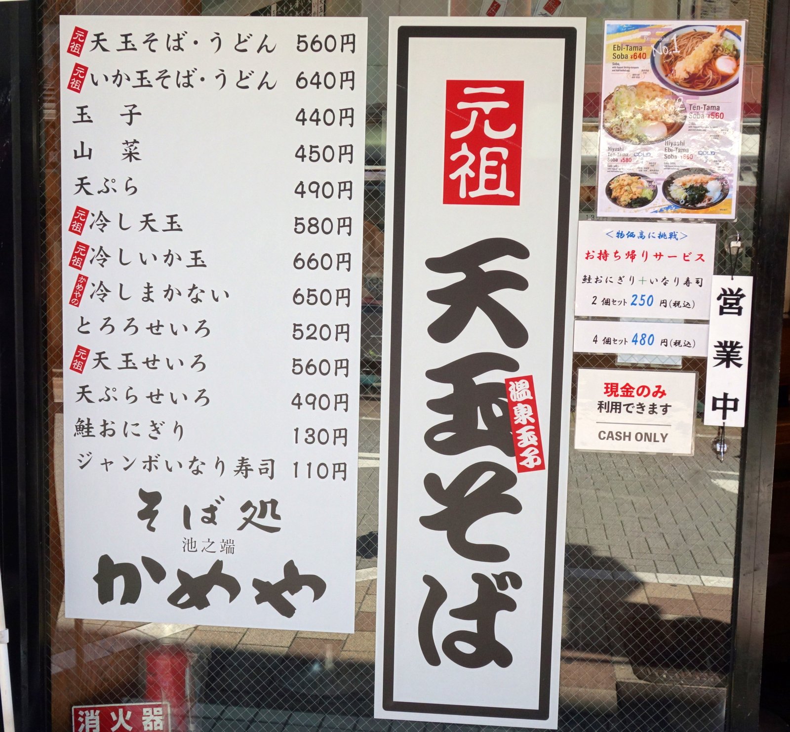 店外の壁に貼られた縦長の「元祖 天玉そば」パネルと、メニュー一覧