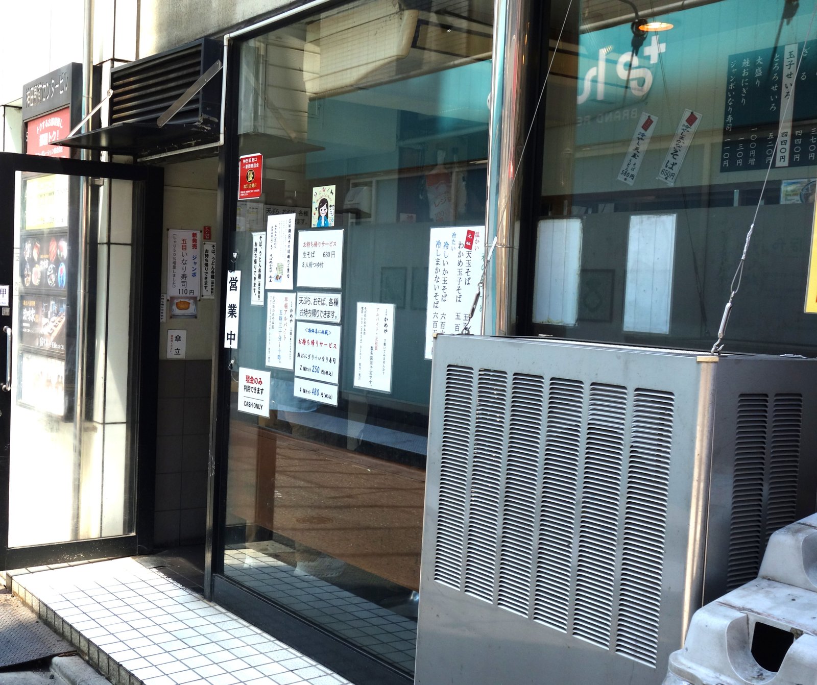 かめや 神田東口店のもう一方の出入口。営業中の掛札と店外貼紙が見える