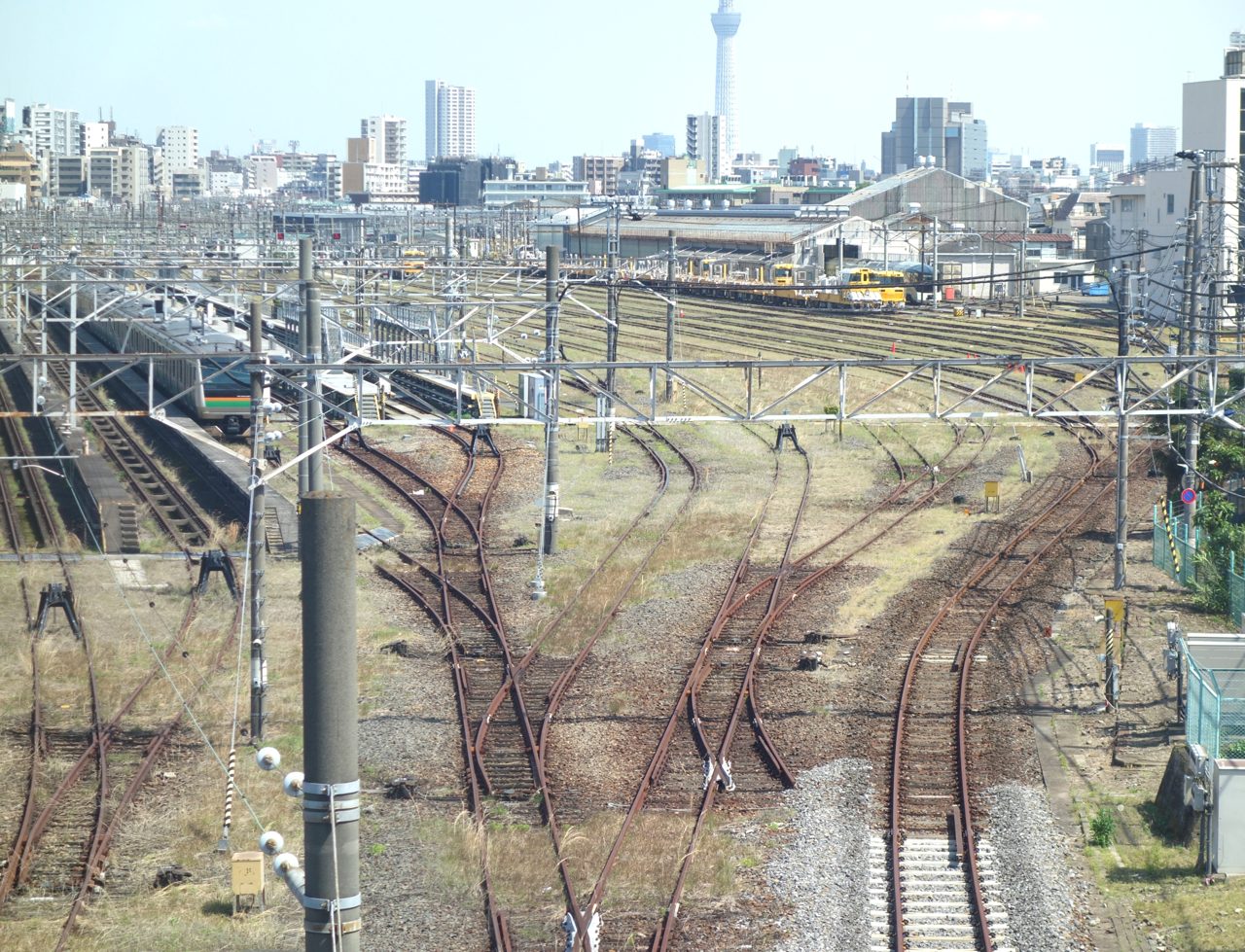尾久車両基地に並ぶ電車。オレンジと緑の近郊電車や黄色い作業用車両