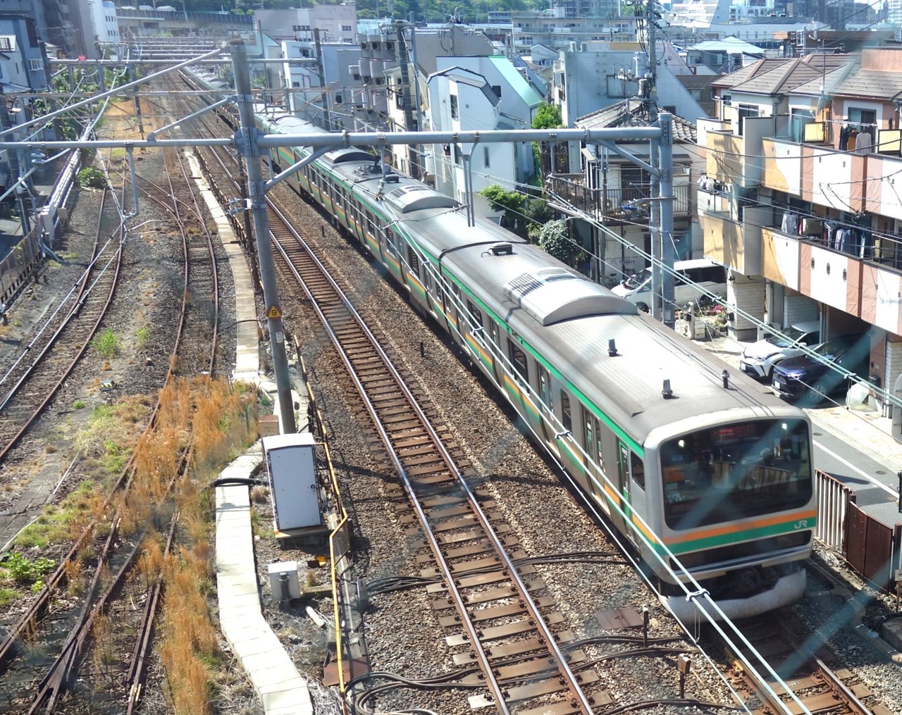 上中里さわやか橋から見下ろした、カーブを走り抜けるオレンジと緑の帯の近郊電車