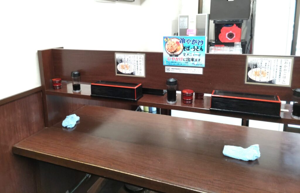 そばよし京橋店のカウンター席（椅子あり）と卓上の薬味