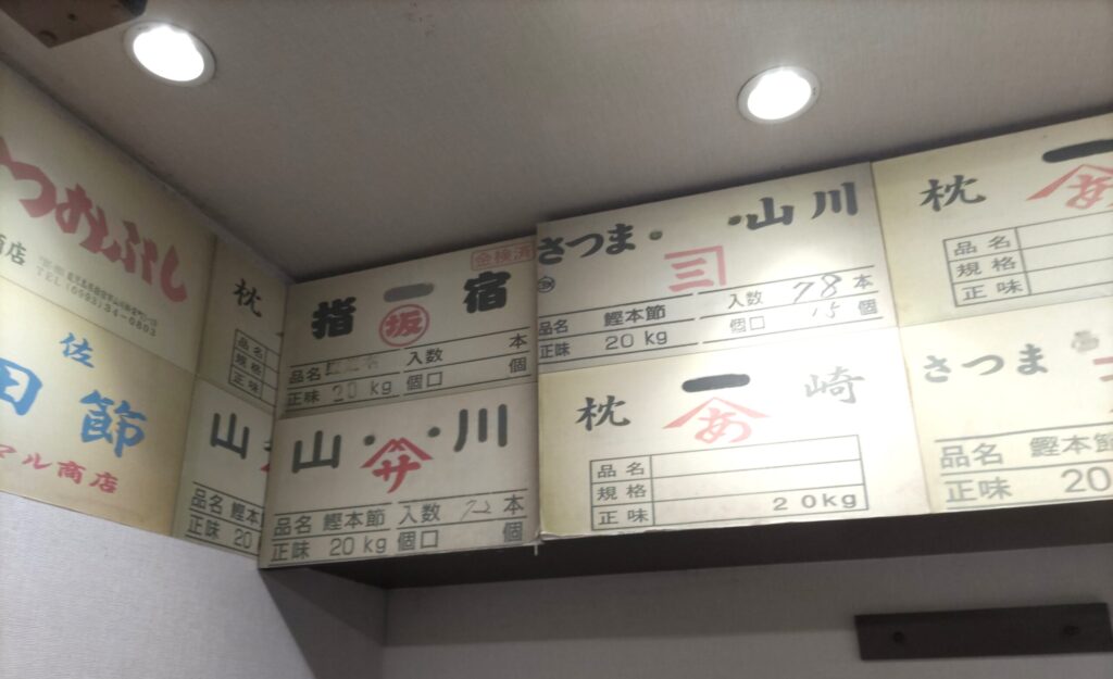 店内の壁・天井を埋める鰹本節の問屋札（さつま・佐田節ほか）＝そばよし京橋店の鰹節問屋直営の証