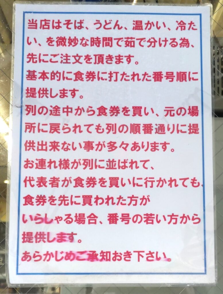 そばよし京橋店の案内。茹で分けのため先に食券を買い、番号順に提供される旨の張り紙