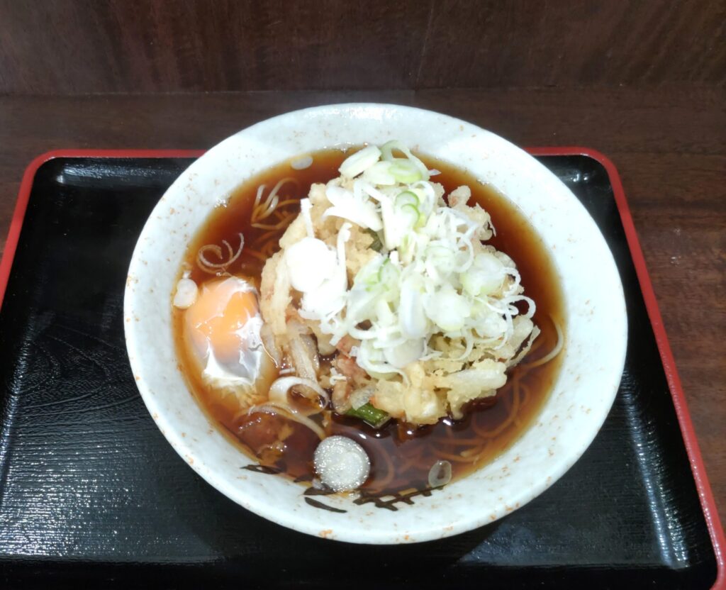 そばよし京橋店の天玉そば（610円）を上から見たところ。かき揚げ・生卵・たっぷりの刻みネギ
