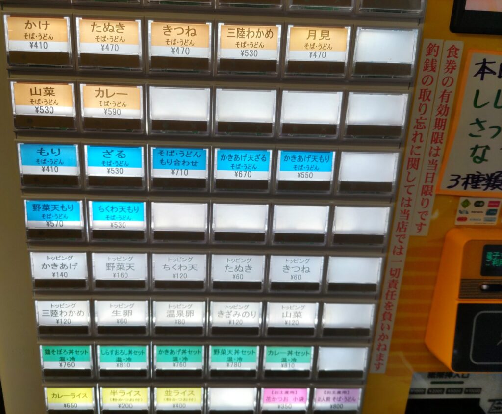 そばよし京橋店の券売機のボタン拡大。天玉そば610円など各メニューの価格がわかる