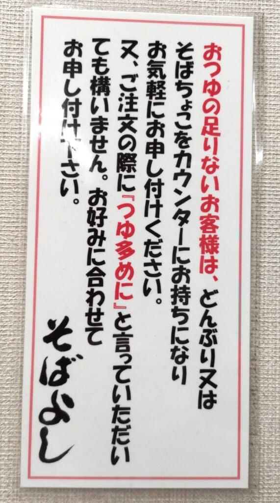 そばよし京橋店の張り紙。つゆが足りなければ「つゆ多めに」と頼める案内