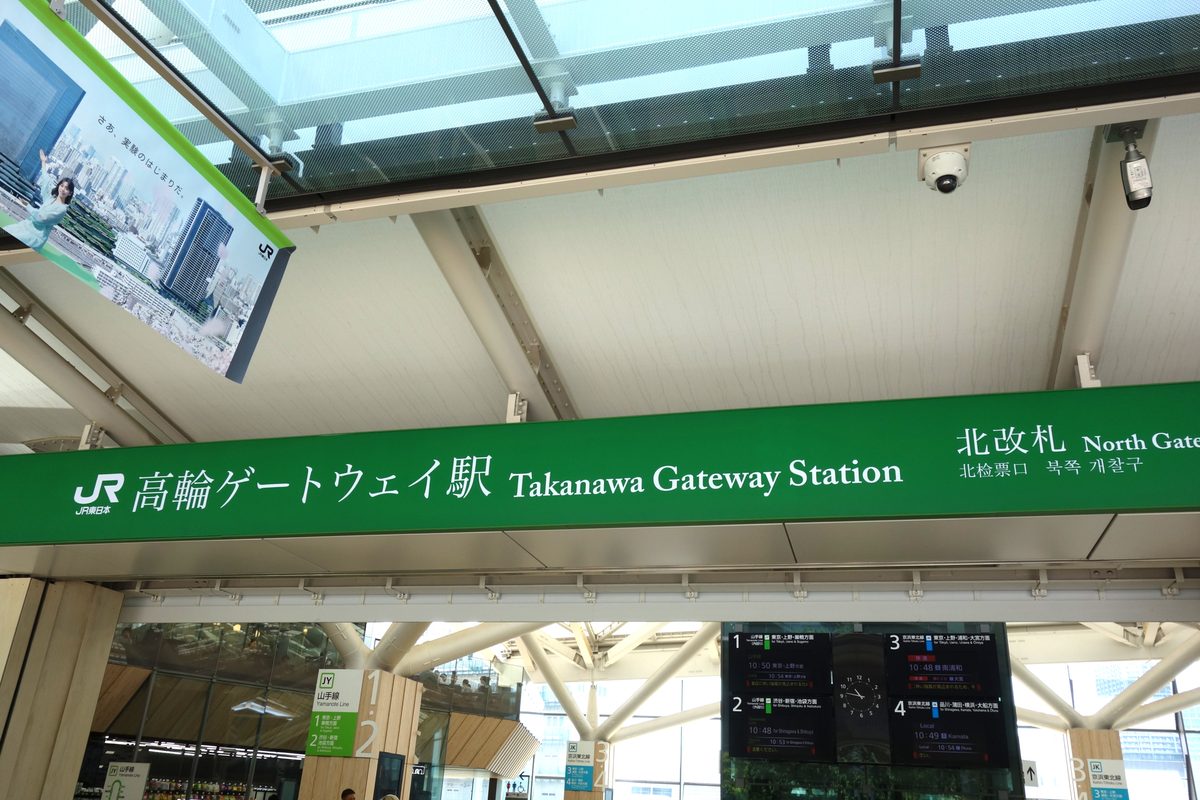 高輪ゲートウェイ駅の北改札(北口)。JRの緑の駅名標と隈研吾デザインの白い膜屋根