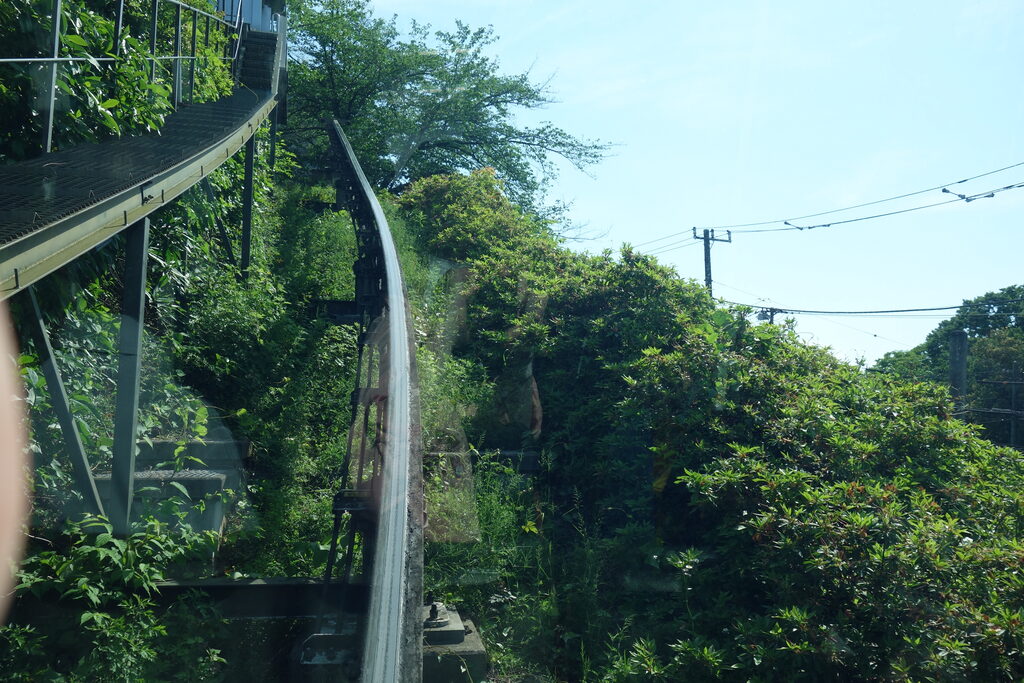 飛鳥山公園モノレールのレールが斜面をカーブしながら続く様子。車窓の外の緑