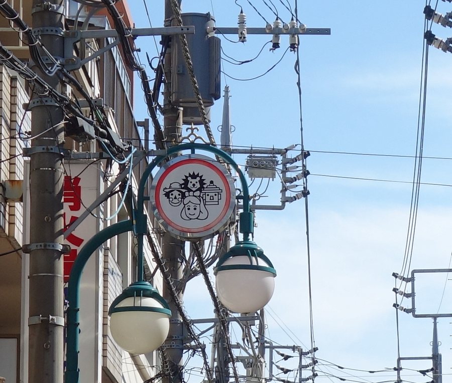 オズ通り商店街の街灯に掲げられたオズの魔法使いのキャラクターの丸い看板