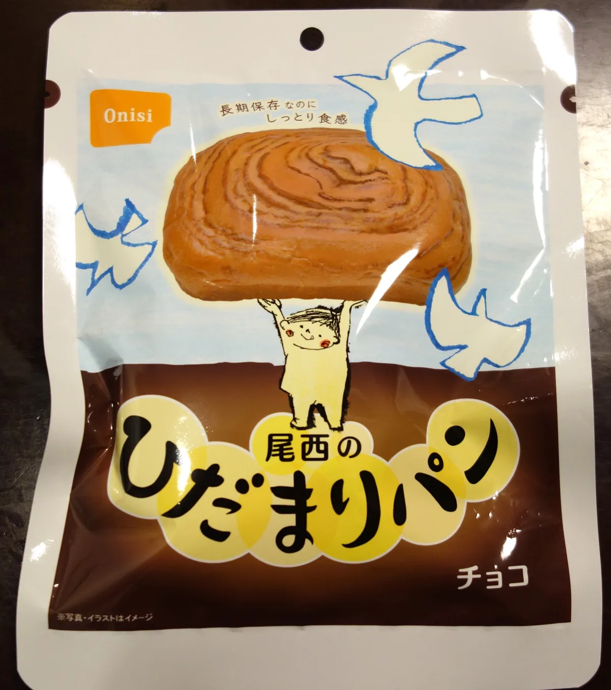 尾西のひだまりパン チョコのパッケージ表面。Onisiのロゴとハトのマーク、「長期保存なのにしっとり食感」の表示