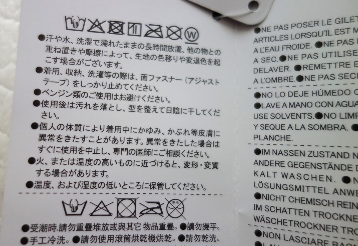 お手入れ表示タグの接写。手洗いの洗濯記号と、使用後は汚れを落とし型を整えて日陰に干す、ベンジン類は避ける、といった注意書き