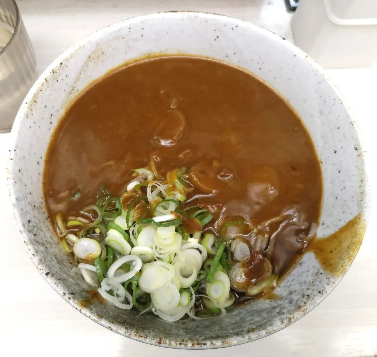 品川駅常盤軒のカレーそば620円。カレーの下に黒いつゆ、ネギがたっぷり