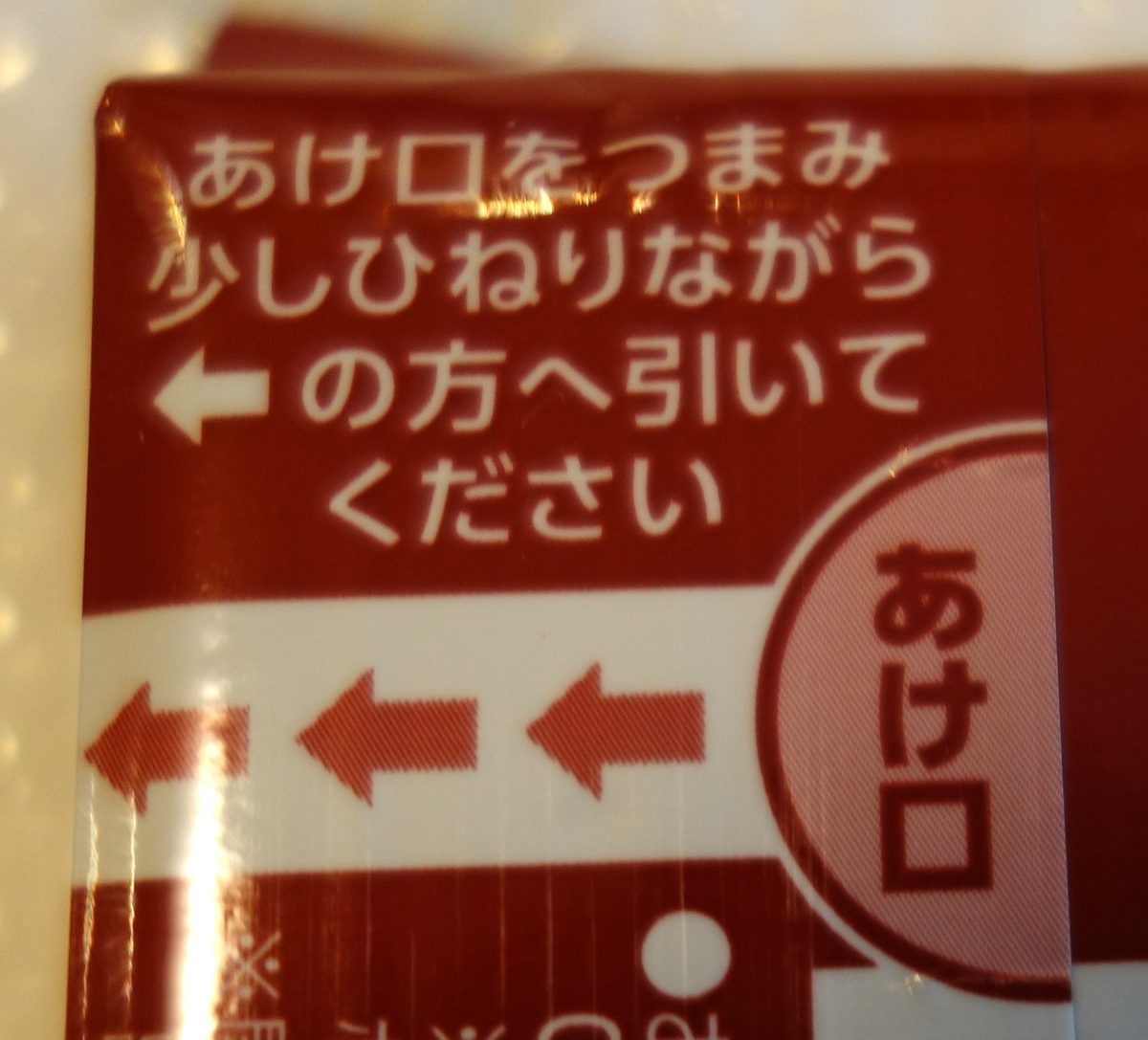 えいようかん個包装のあけ口（つまんで少しひねりながら引く）