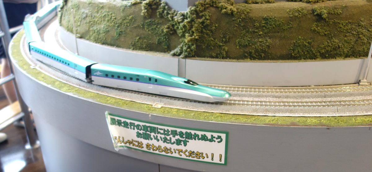 ホビーセンターカトー東京1階の巨大レイアウト。入口近くの螺旋状の高架を走る北海道新幹線H5系